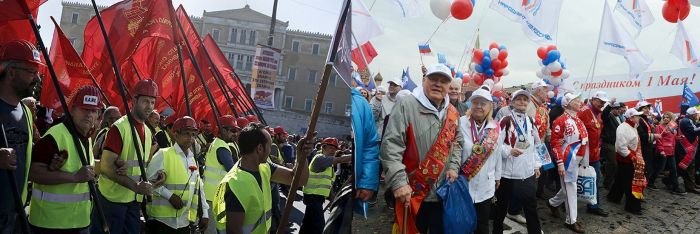Protesters from the trade union PAME hold red flags during the May Day rally in front of the parliament building in Athens, Greece (left). People march in Moscow marking Labour Day.